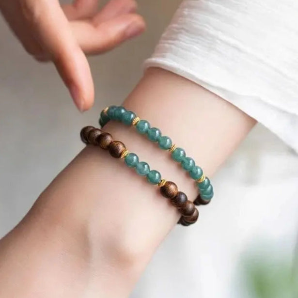 Bracelet double L'Atelier Wen en bois d’agar et perles vert jade, monté sur fil élastique, bijou artisanal aux finitions dorées inspiré de la tradition bouddhiste.